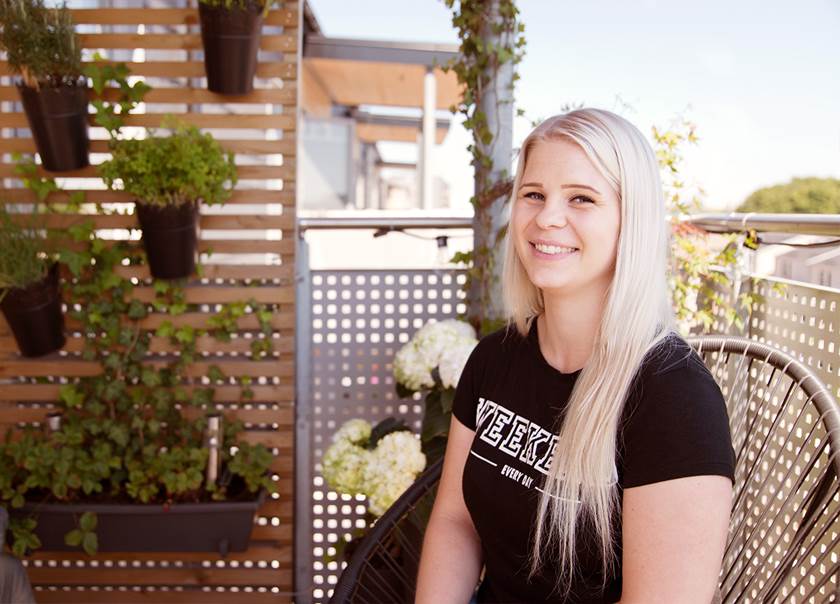 Emma Malmborg ler och sitter på sin balkong 